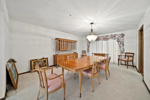 a view of a dining room with furniture and a chandelier