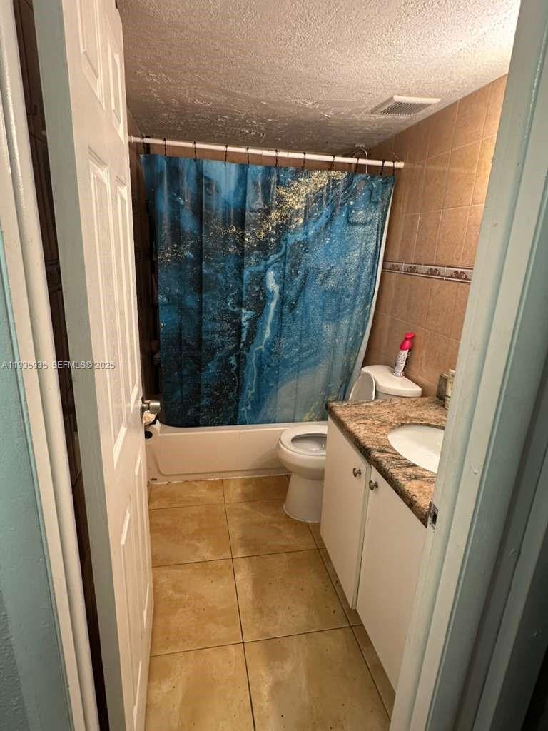 1875 West 56th Street, Unit 301 Hialeah, FL 33012 - Photo 12 of 17 a bathroom with a granite countertop sink a toilet a shower and a mirror