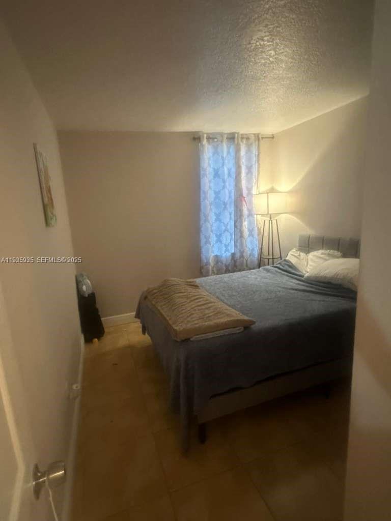 1875 West 56th Street, Unit 301 Hialeah, FL 33012 - Photo 13 of 17 a bedroom with a bed and a window