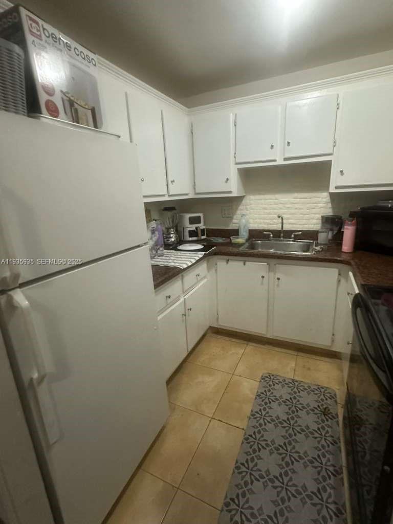 1875 West 56th Street, Unit 301 Hialeah, FL 33012 - Photo 9 of 17 a kitchen with stainless steel appliances granite countertop a sink stove refrigerator and cabinets