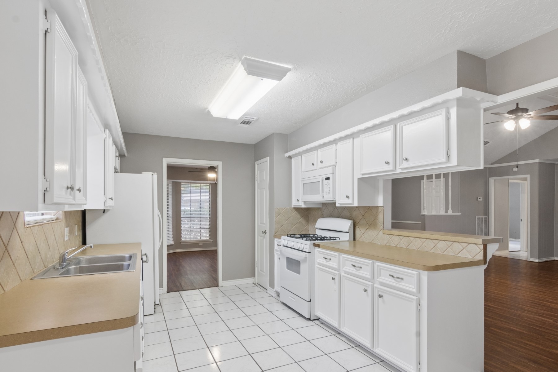 2607 Allyson Court Spring, TX 77373 - Photo 10 of 25 a kitchen with granite countertop a sink stove and cabinets