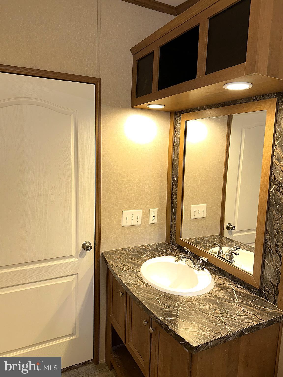 1277 Ritchie Highway, Unit 195 Arnold, MD 21012 - Photo 19 of 30 a bathroom with a granite countertop sink and a mirror