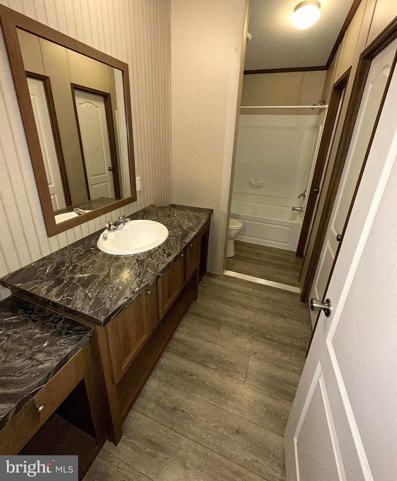1277 Ritchie Highway, Unit 195 Arnold, MD 21012 - Photo 24 of 30 a bathroom with a granite countertop sink and a mirror