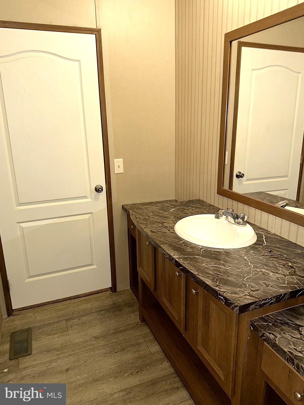 1277 Ritchie Highway, Unit 195 Arnold, MD 21012 - Photo 25 of 30 a bathroom with a granite countertop sink and a mirror