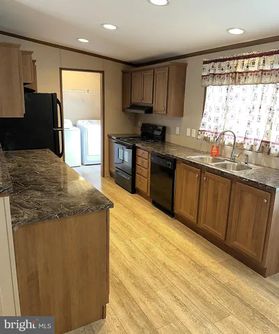 a kitchen with granite countertop sink stainless steel appliances and a window