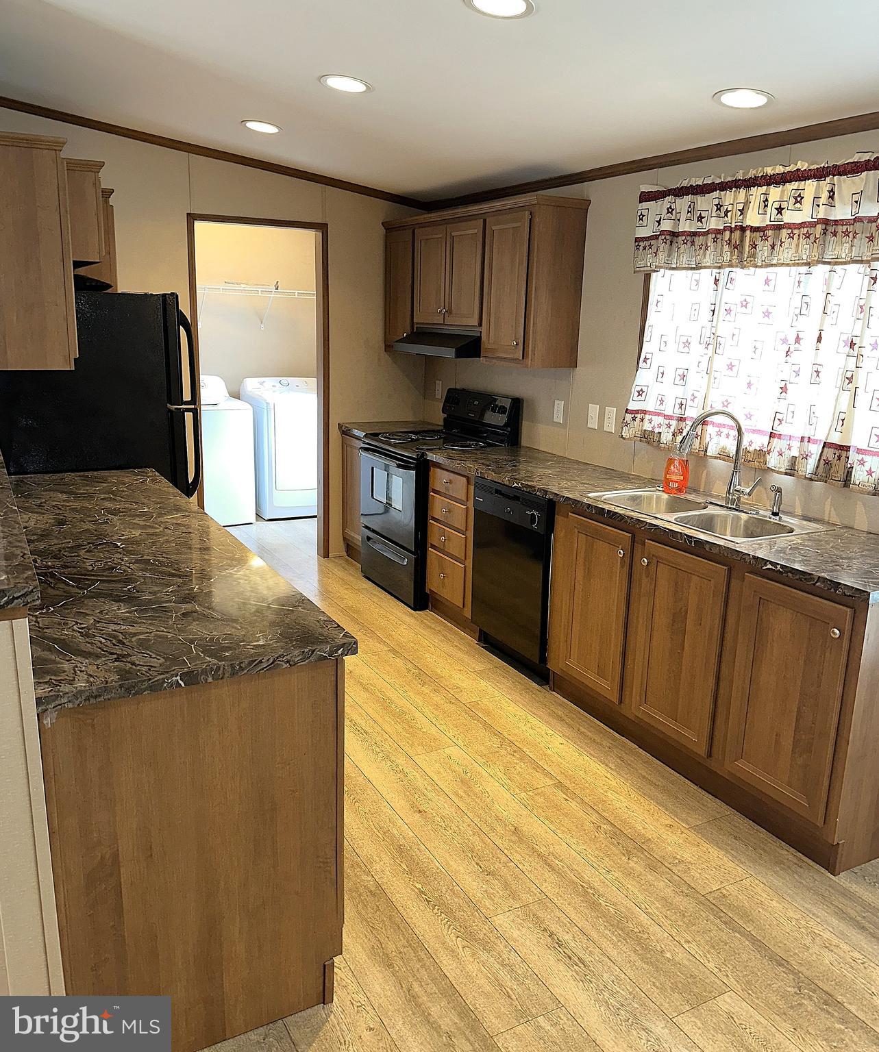 1277 Ritchie Highway, Unit 195 Arnold, MD 21012 - Photo 5 of 30 a kitchen with granite countertop sink stainless steel appliances and a window