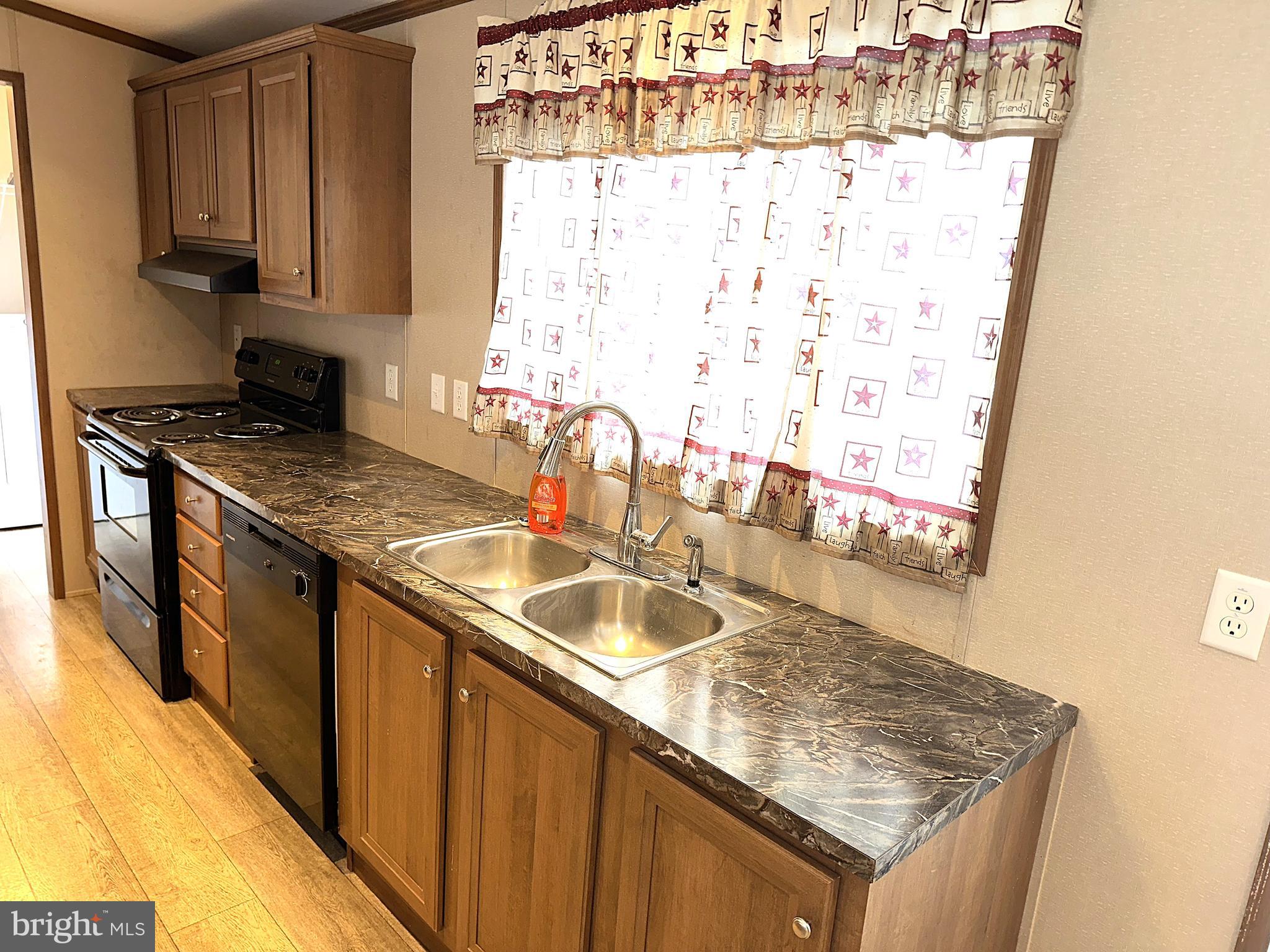 1277 Ritchie Highway, Unit 195 Arnold, MD 21012 - Photo 6 of 30 a kitchen with granite countertop a sink stove and cabinets