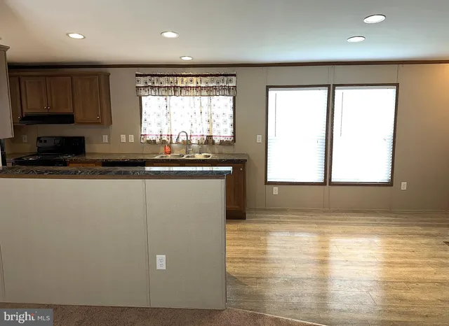 a kitchen with stainless steel appliances granite countertop a sink a stove a microwave a counter space and cabinets