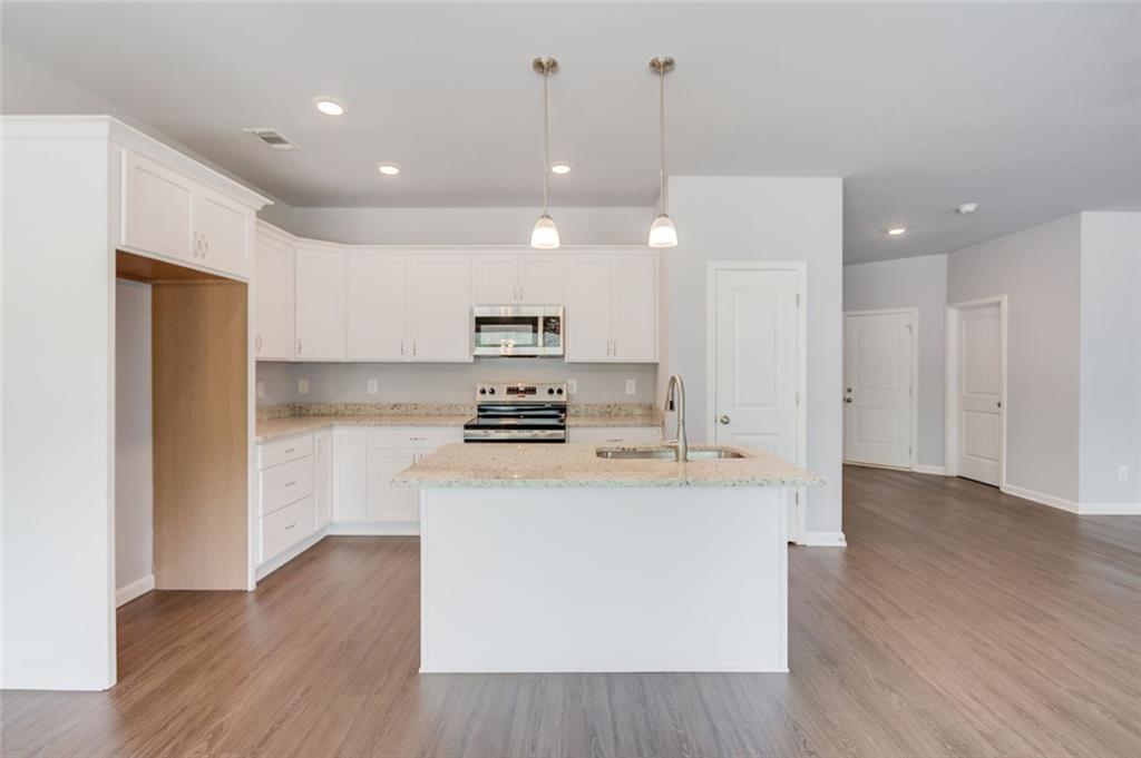 771 Dortch Road Eastanollee, GA 30538 - Photo 14 of 38 a kitchen with kitchen island a sink a stove a refrigerator and white cabinets