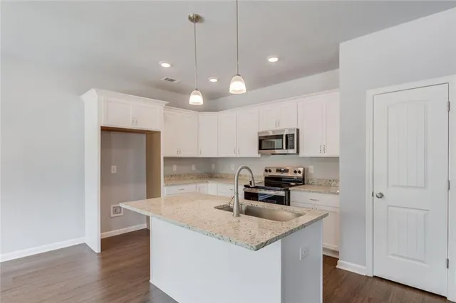 a kitchen with stainless steel appliances granite countertop a sink a stove and a refrigerator