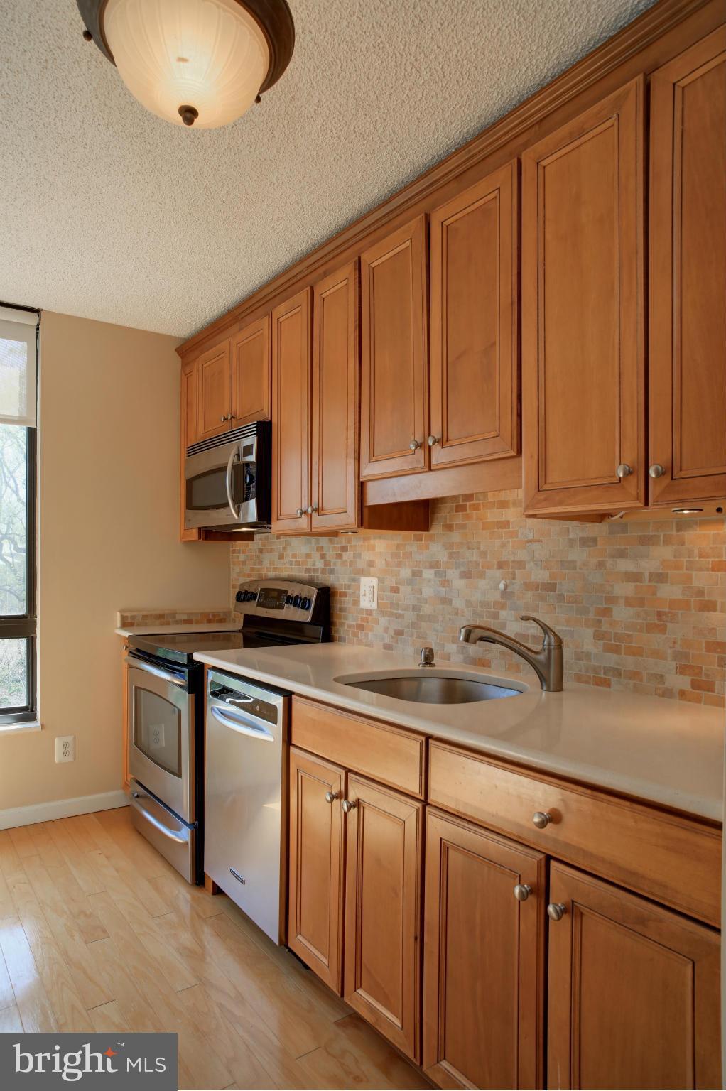1800 Old Meadow Road, Unit 713 McLean, VA 22102 - Photo 1 of 27 a kitchen with stainless steel appliances granite countertop a sink a stove a microwave and cabinets