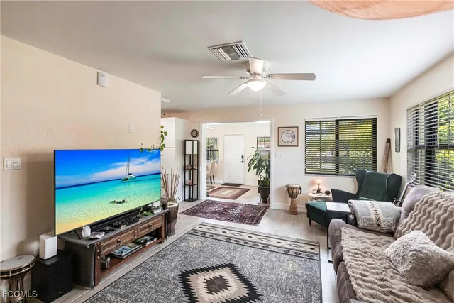 a living room with furniture flat screen tv and a large window