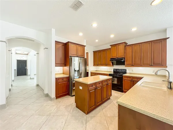 a kitchen with stainless steel appliances granite countertop a sink and dishwasher a stove top oven with wooden floor