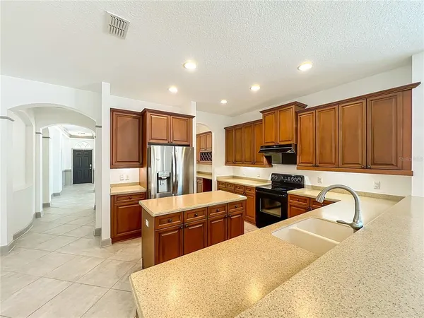 a living room with stainless steel appliances kitchen island granite countertop a sink and cabinets