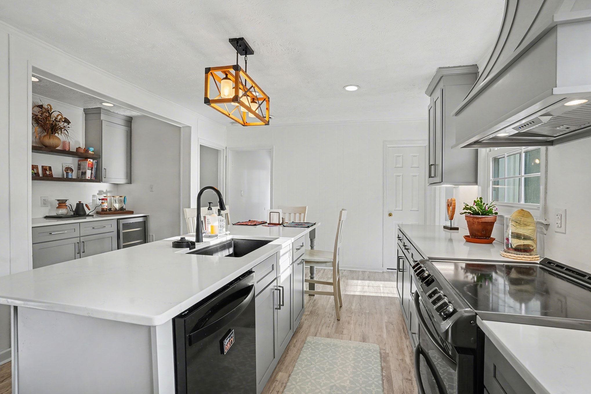 317 Jay Street Murrells Inlet, SC 29576 - Photo 12 of 36 Kitchen with gray cabinets, black appliances, custom exhaust hood, recessed lighting, and crown molding