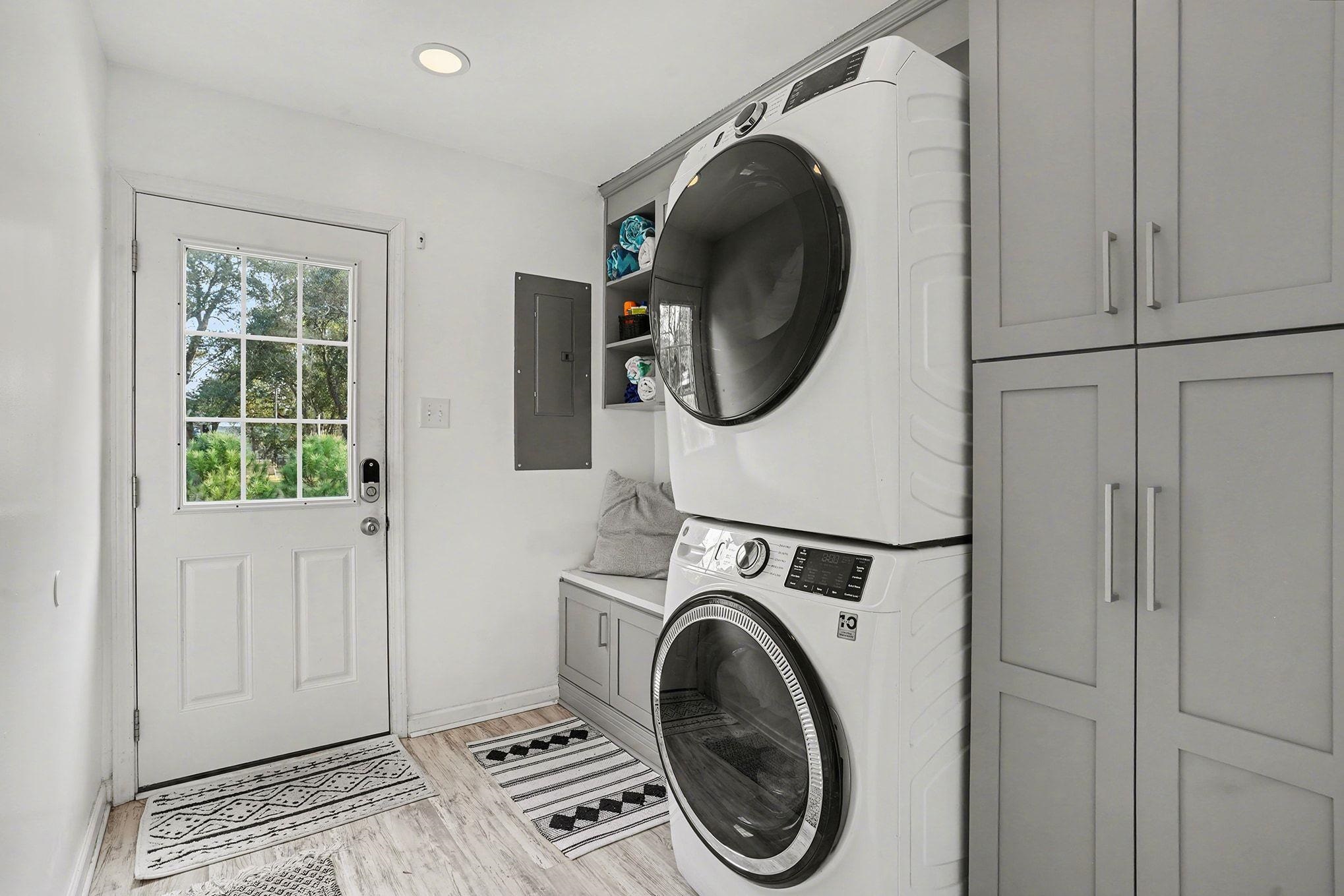 317 Jay Street Murrells Inlet, SC 29576 - Photo 15 of 36 Laundry room with cabinet space, stacked washer and clothes dryer, electric panel, and light wood finished floors