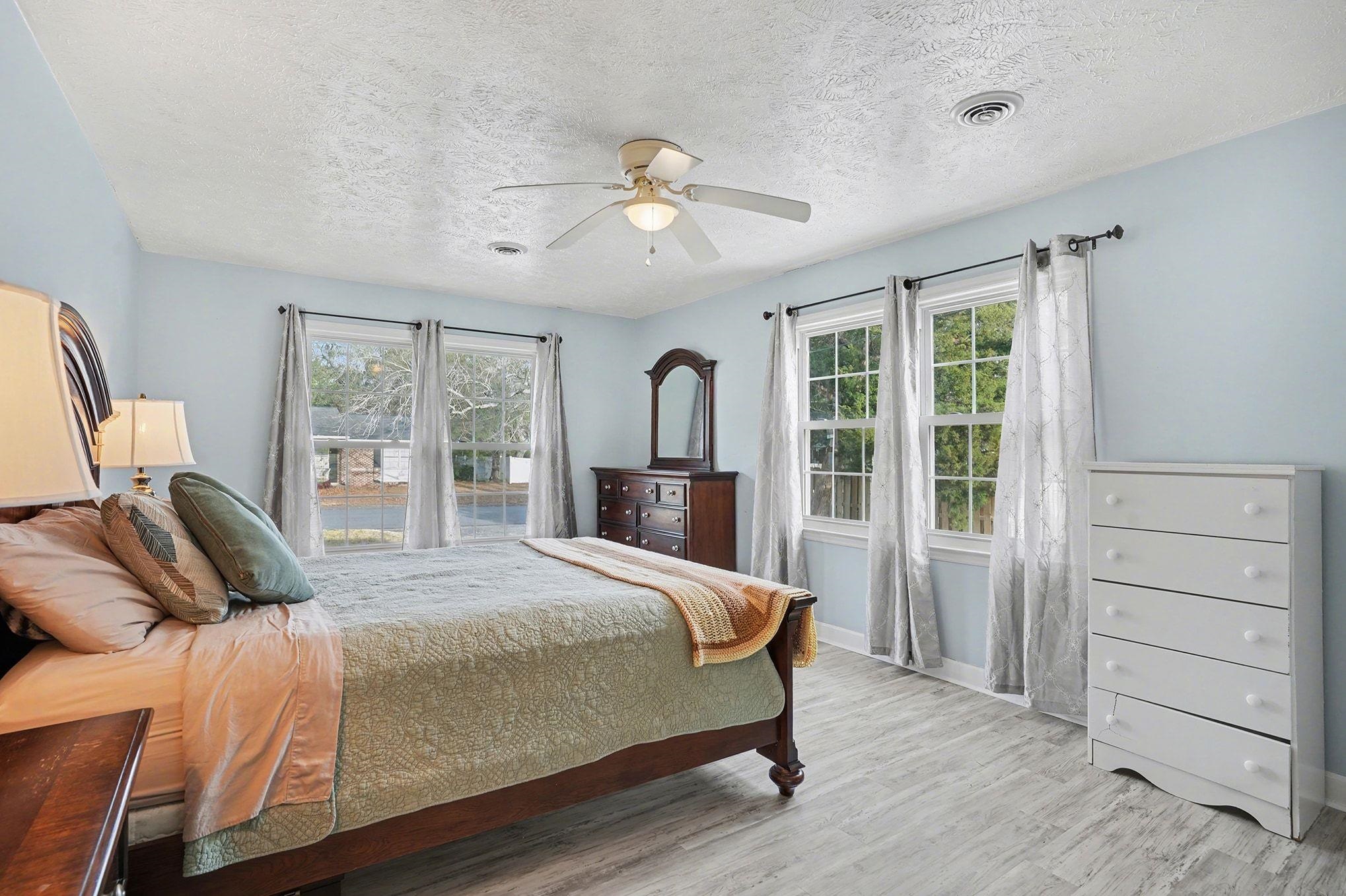 317 Jay Street Murrells Inlet, SC 29576 - Photo 24 of 36 Bedroom with a ceiling fan, light wood-style flooring, a textured ceiling, and multiple windows
