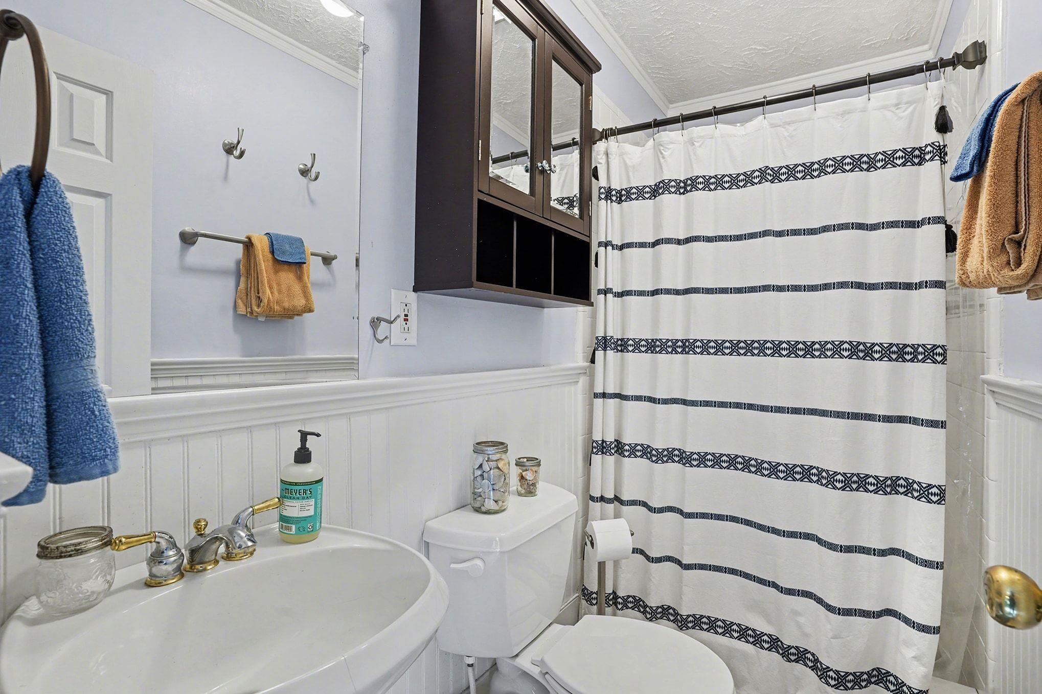 317 Jay Street Murrells Inlet, SC 29576 - Photo 27 of 36 Bathroom featuring ornamental molding, a shower with curtain, wainscoting, a textured ceiling, and a decorative wall