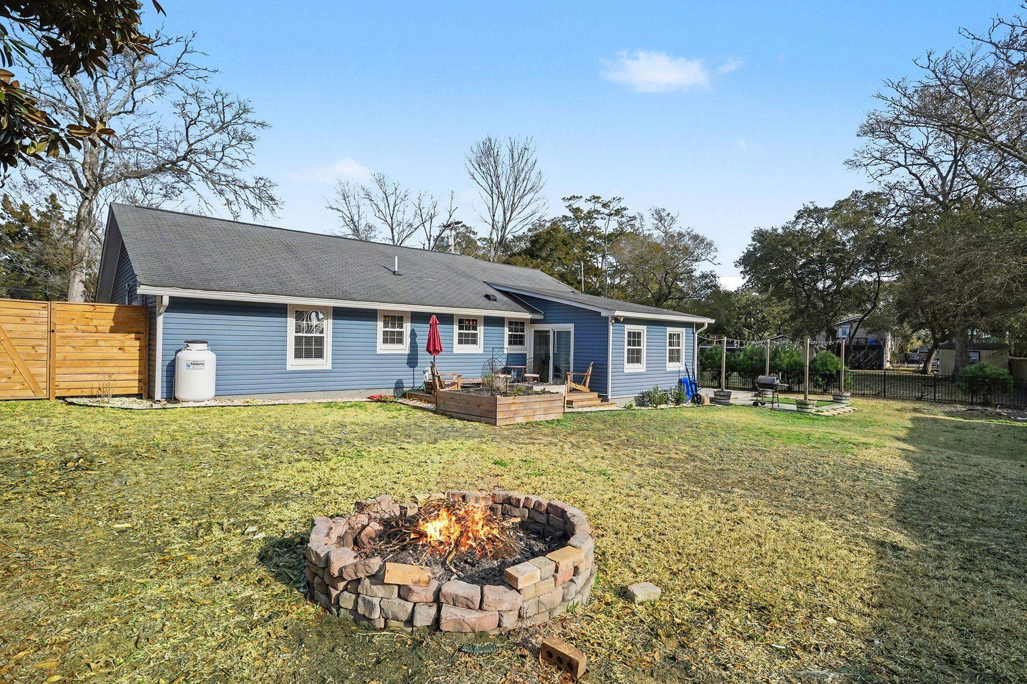 317 Jay Street Murrells Inlet, SC 29576 - Photo 33 of 36 Rear view of property with a fire pit, a fenced backyard, a vegetable garden, a wooden deck, and a patio area