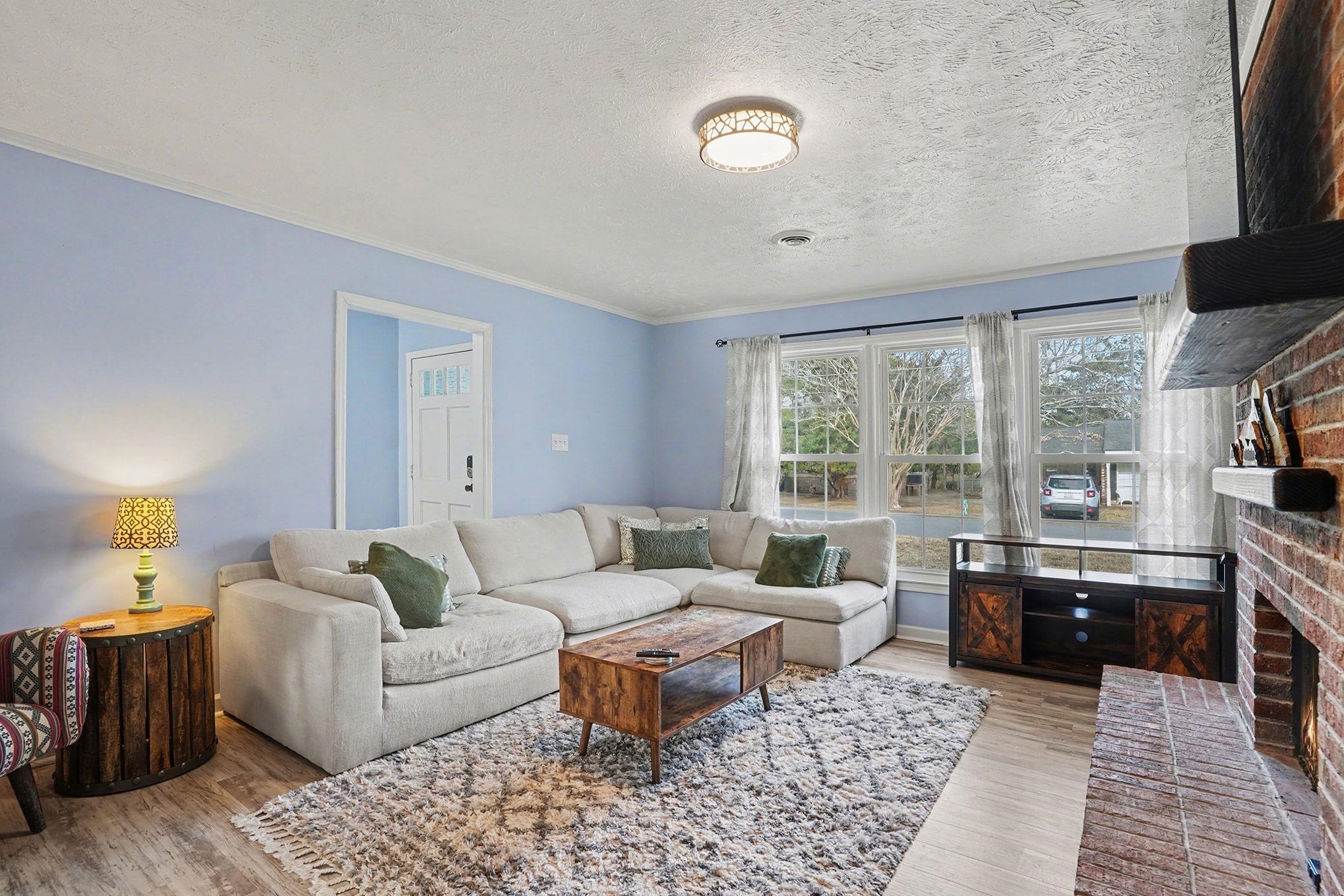 317 Jay Street Murrells Inlet, SC 29576 - Photo 5 of 36 Living room featuring a brick fireplace, a textured ceiling, light wood-type flooring, and ornamental molding