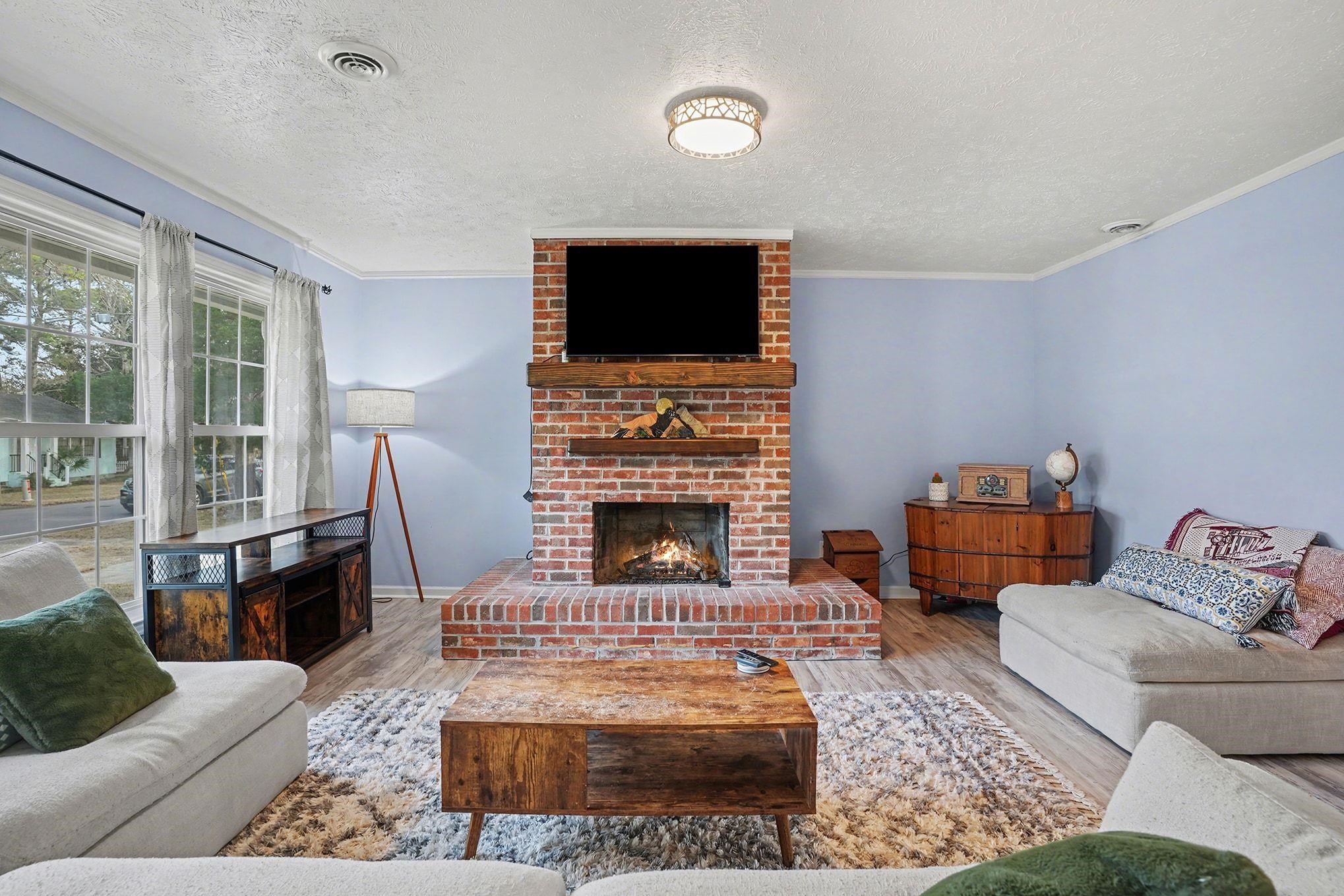 317 Jay Street Murrells Inlet, SC 29576 - Photo 7 of 36 Living area with wood finished floors, a fireplace, crown molding, and a textured ceiling