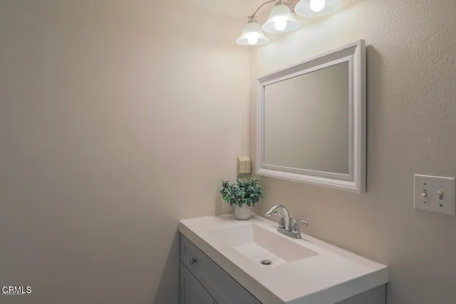 a bathroom with a sink vanity and a mirror
