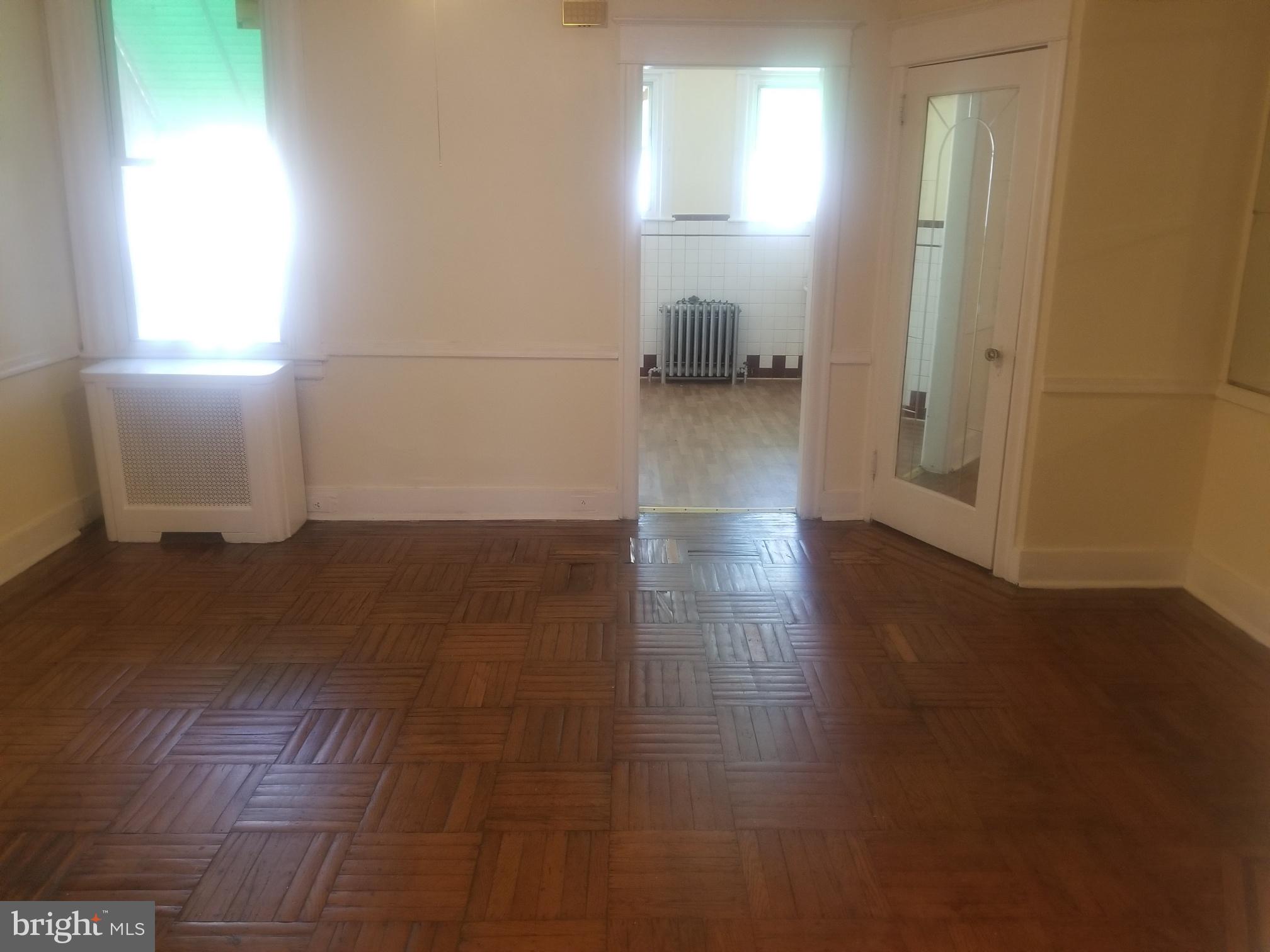 226 Copley Road Upper Darby, PA 19082 - Photo 4 of 10 an empty room with wooden floor and a window