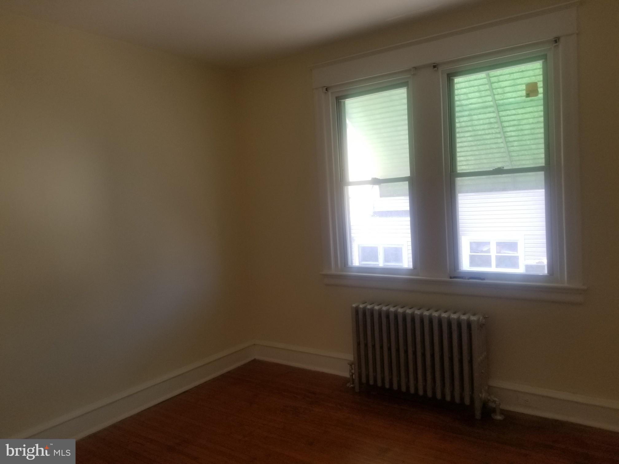 226 Copley Road Upper Darby, PA 19082 - Photo 6 of 10 an empty room with wooden floor and windows