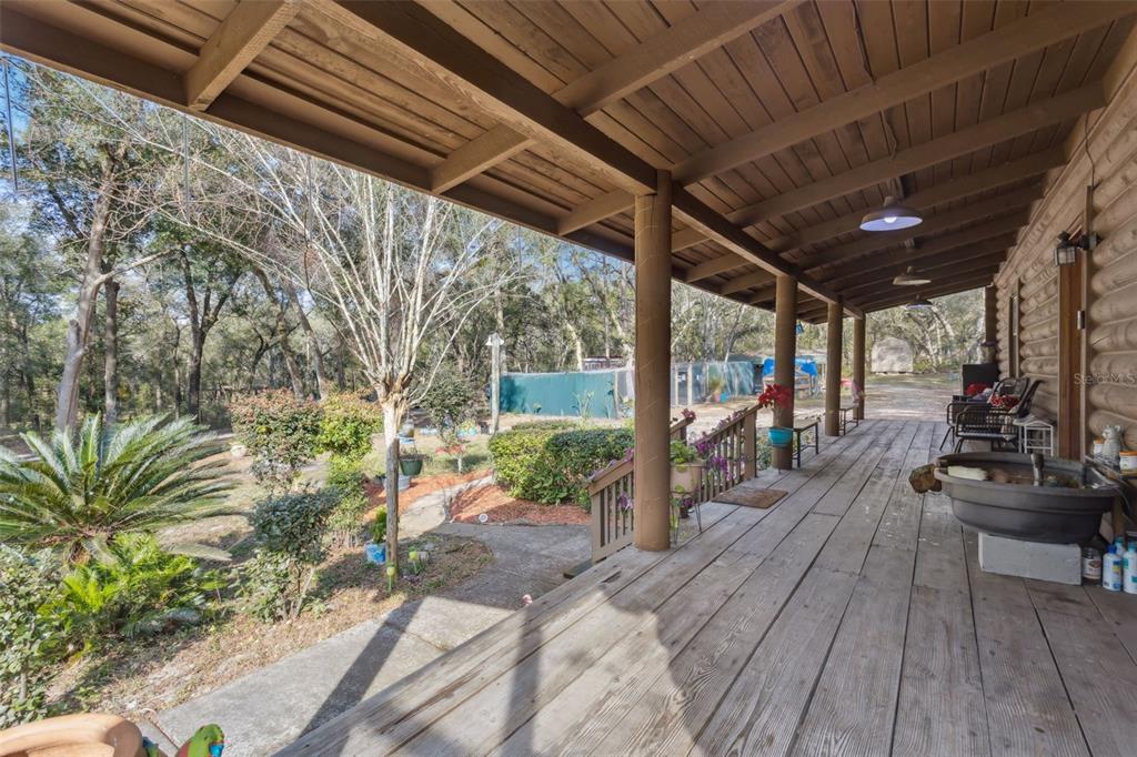 1208 D Arcy Road Lady Lake, FL 32159 - Photo 5 of 50 a view of a patio with table and chairs potted plants with wooden floor