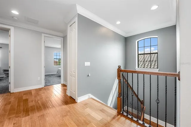 a bedroom with wooden floor and a window