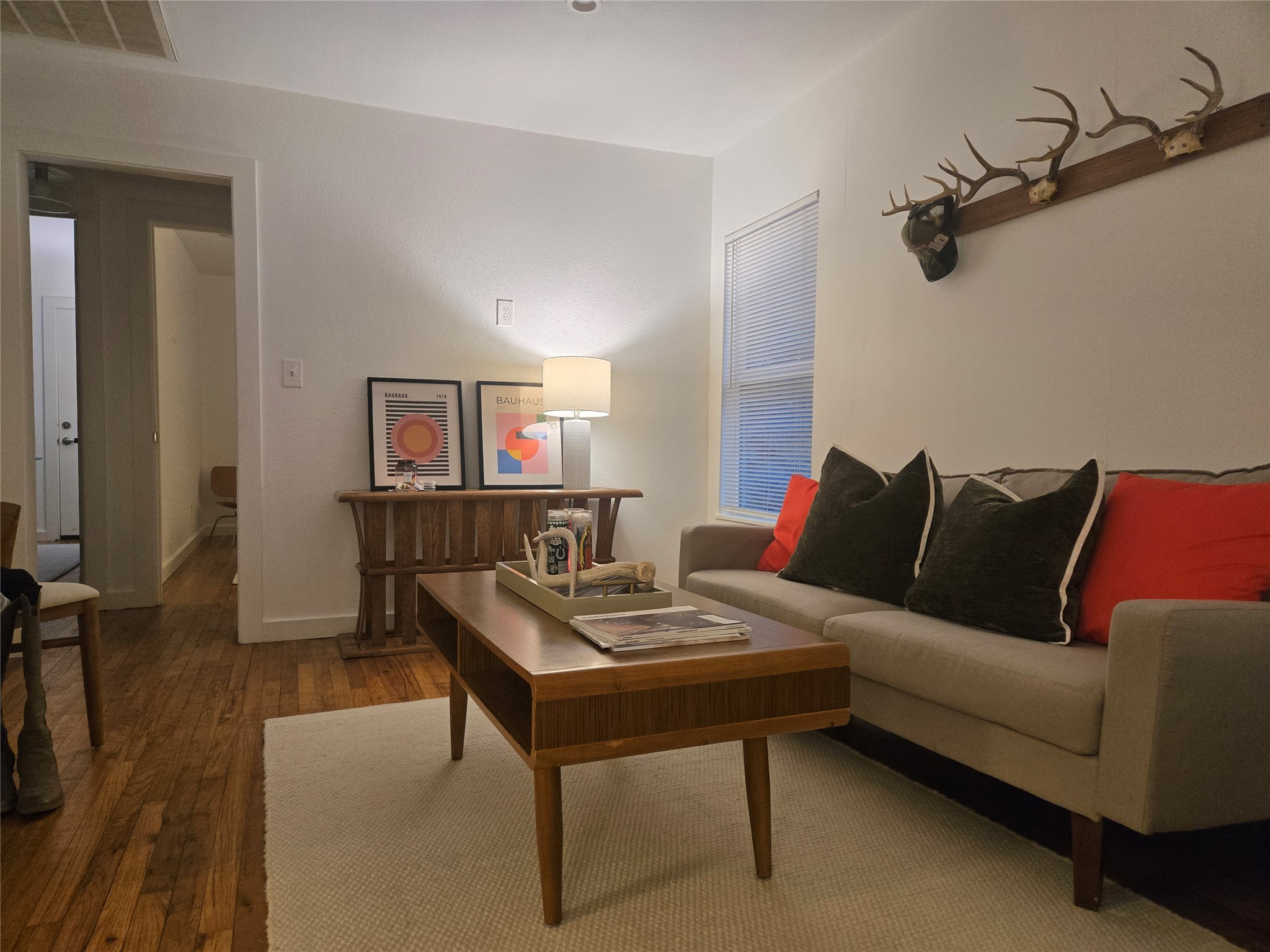 Living area featuring dark wood-style flooring and baseboards
