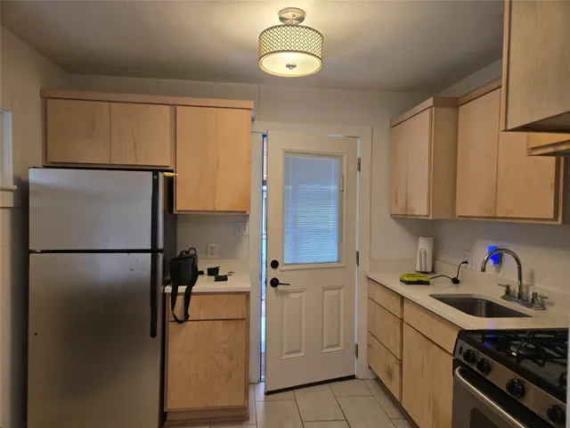 a kitchen with a refrigerator and a stove top oven
