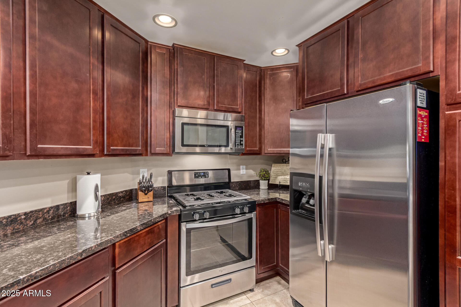 5350 East Deer Valley Drive, Unit 1259 Phoenix, AZ 85054 - Photo 7 of 35 a kitchen with granite countertop wooden cabinets and stainless steel appliances