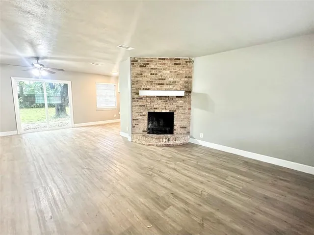wooden floor fireplace and windows in an empty room
