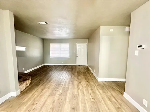 a view of a room with wooden floor and window