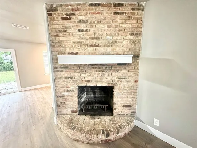 a living room with a fireplace and a wooden floor