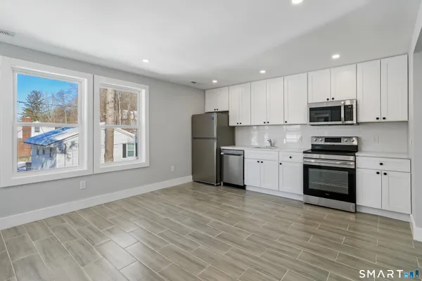 a kitchen with stainless steel appliances granite countertop a stove a sink and a refrigerator