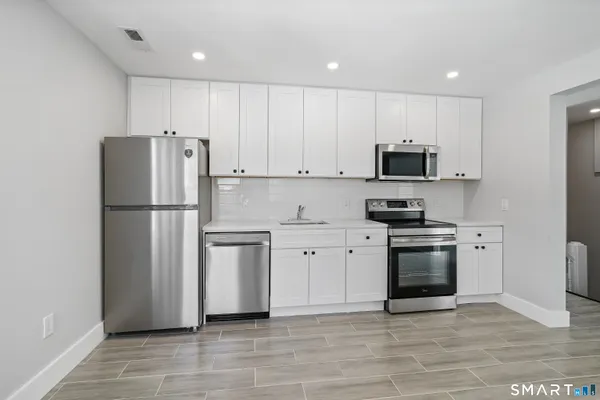 a kitchen with stainless steel appliances granite countertop a refrigerator stove a sink and a granite counter tops