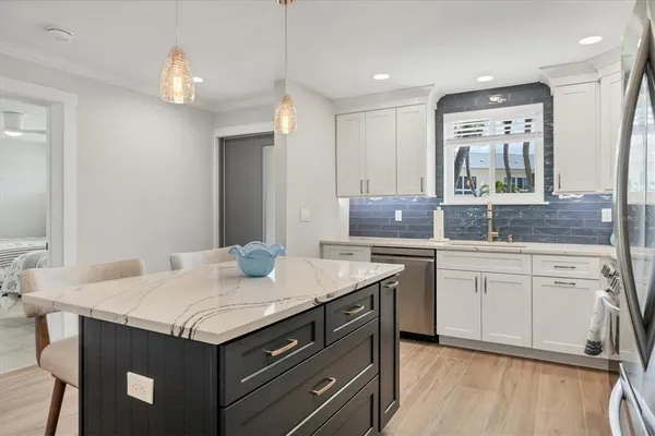 a kitchen with a sink dishwasher a stove and a refrigerator with wooden floor