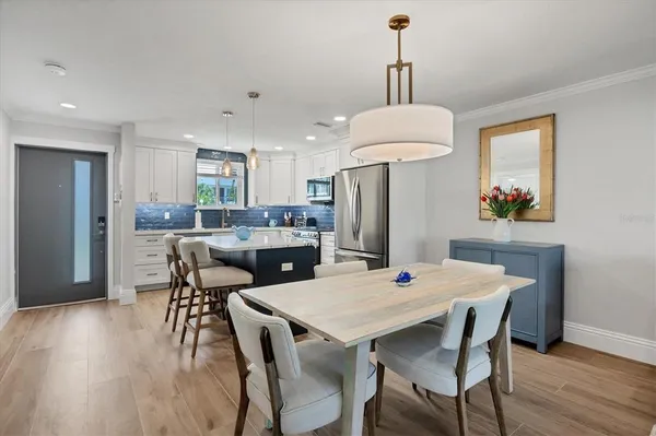 a dining room with furniture a chandelier and wooden floor