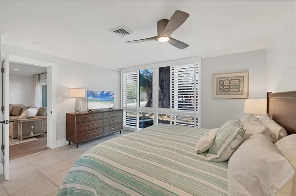 a bedroom with furniture large window and bed