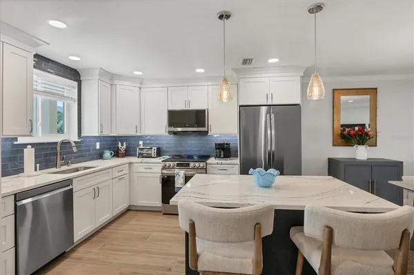 a kitchen with stainless steel appliances kitchen island a sink stove and refrigerator