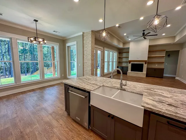 a kitchen with kitchen island granite countertop a sink and a large window