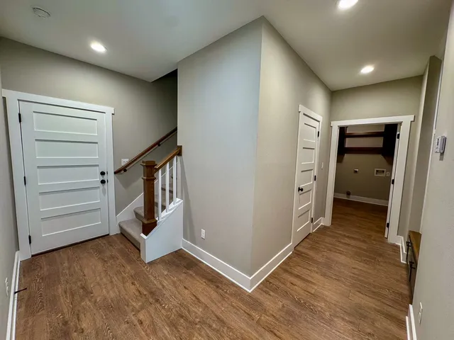 a view of hallway with stairs and wooden floor