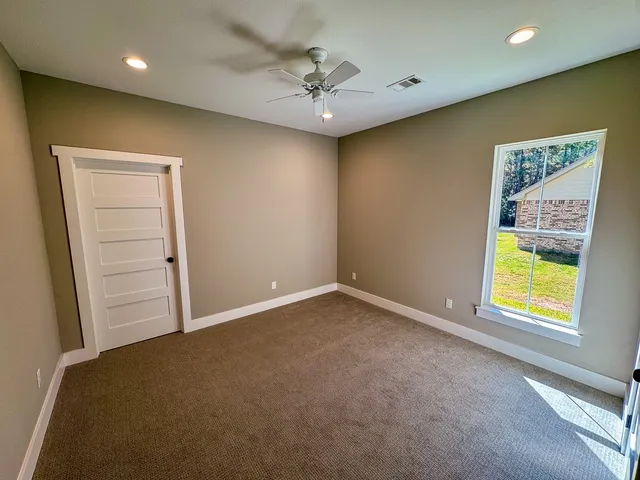 an empty room with a window and a ceiling fan