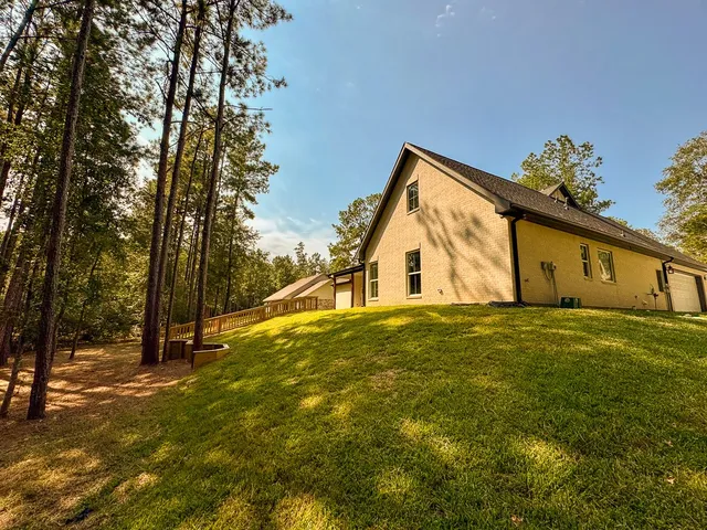 a view of a house with backyard and tree