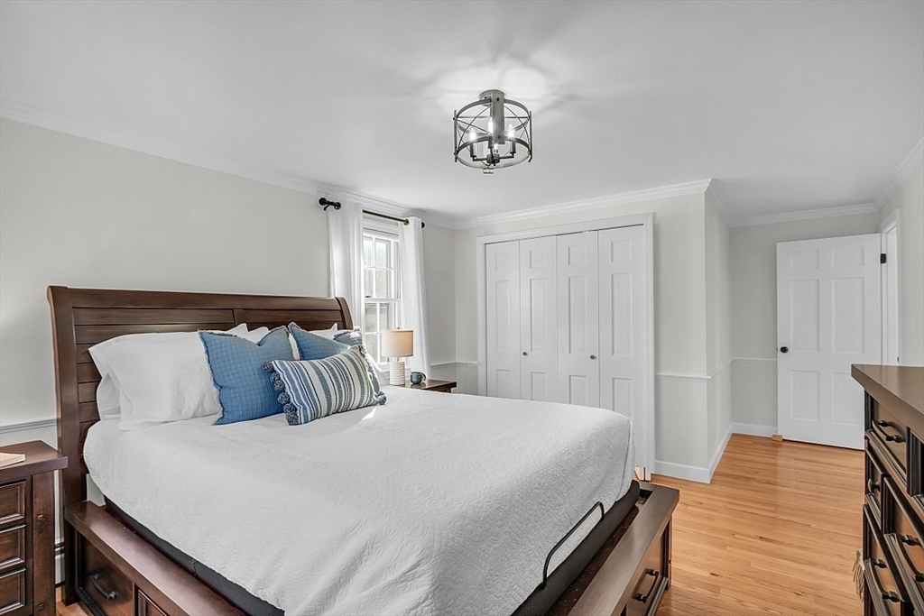 114 Bailey Road Andover, MA 01810 - Photo 19 of 42 a bedroom with a bed and a chandelier