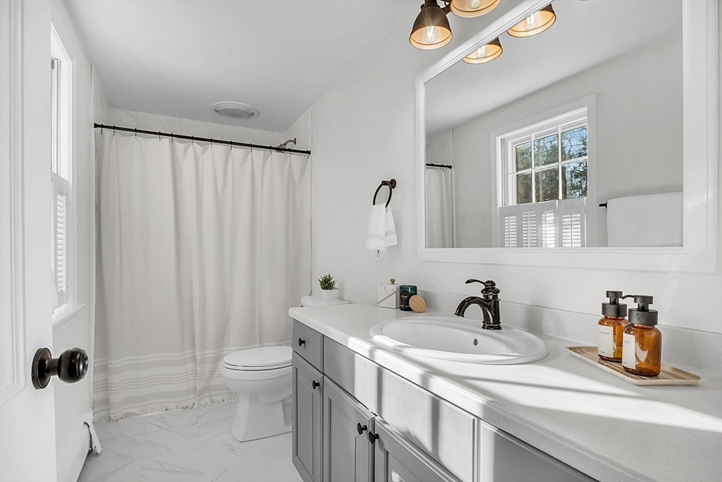 114 Bailey Road Andover, MA 01810 - Photo 20 of 42 a bathroom with a sink a toilet and shower curtain