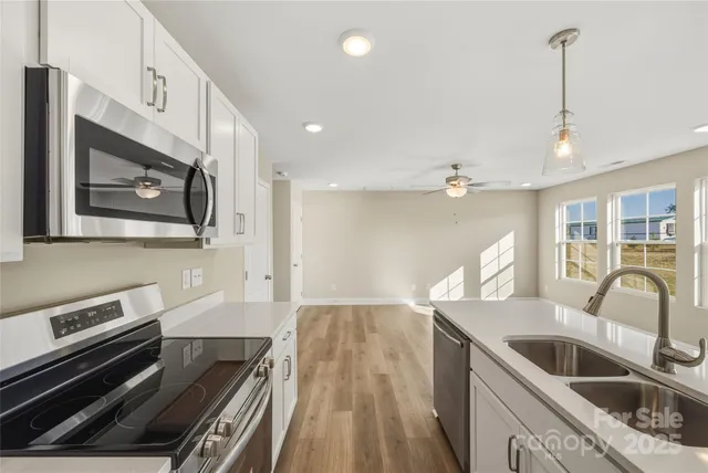 a kitchen with stainless steel appliances granite countertop a sink and a stove