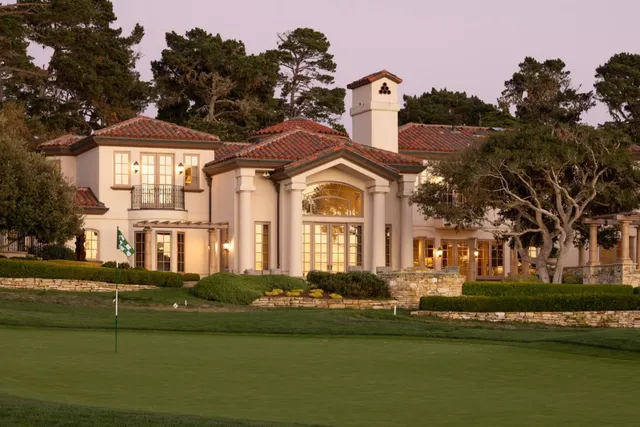 a front view of a house with a garden and lake view